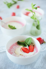 Cold creamy strawberry soup with a scoop of ice cream and mint
