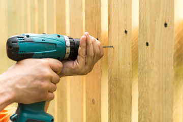 Close up view of cordless electric screwdriver in mans hands