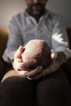 main de papa qui tient la t&ecirc;te de son b&eacute;b&eacute;