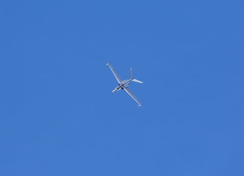 Fouga Magister vintage airplane flying against a blue sky.