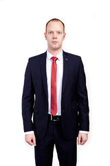 Respectable senior businessman, wearing black suit, white shirt and red tie standing on white background