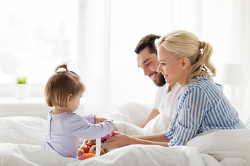 happy family with gift box in bed at home