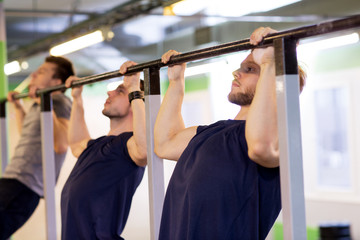 group of young men doing pull-ups in gym