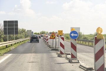 Column flow of vehicles on the road works on the bridge