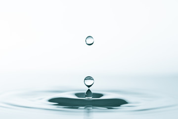 Water drop and splash on water surface on blue background