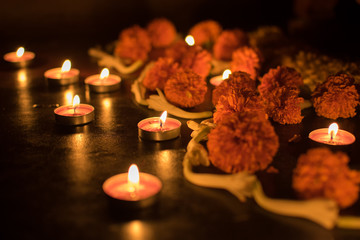 Low angle view of Rangoli flowers and candles or diyas called locally, Diwali lights at night. Dark background stock image of Indian Diwali festival.