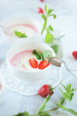 Cold creamy strawberry soup with a scoop of ice cream and mint
