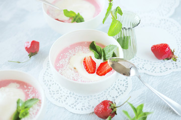 Cold creamy strawberry soup with a scoop of ice cream and mint