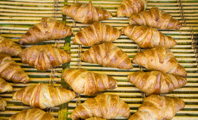 Freshly baked French croissants in street bakery store