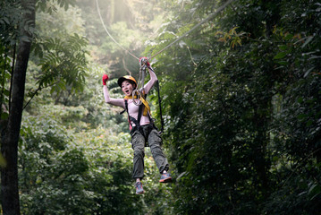 Women tourists freedom on the zip line or roof in Laos. © sirisakboakaew