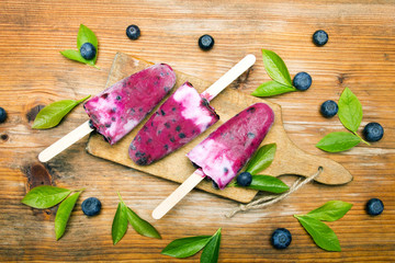 Tasty homemade blueberries ice cream on wooden background. Organic fruit popsicles.