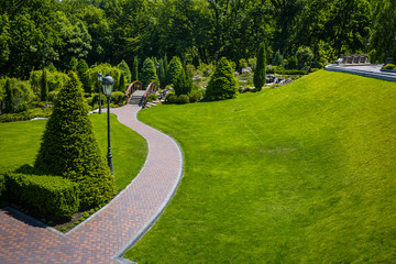 Landscaping in the garden. The path in the garden.Beautiful backyard landscape design,Some flowers and nicely trimmed bushes on the leveled front yard,Landscape formal