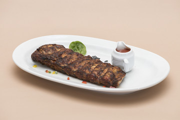  Grilled rib pork with barbecue sauce, placed on white plate, light background, isolated