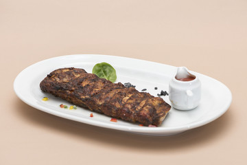  Grilled rib pork with barbecue sauce, placed on white plate, light background, isolated