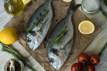 Raw fish cooking and ingredients. Dorado, lemon, herbs and spices.