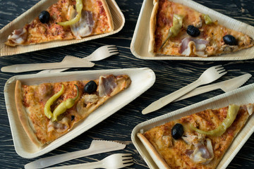 A slices of pizza is on a wooden plate.