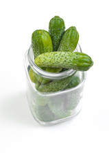 green ripe Cucumbers for preservation in a glass jar isolated on white background