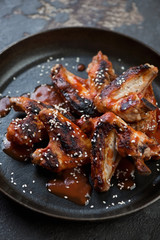 Closeup of bbq chicken wings with tomato sauce and sesame, studio shot