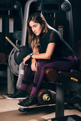 Naklejka na ściany i meble Young fitness woman exercising at the gym