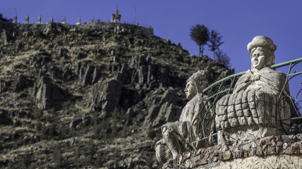 Fototapeta na wymiar Two folk statues with the monte Calvario in Copacabana (Bolivia)