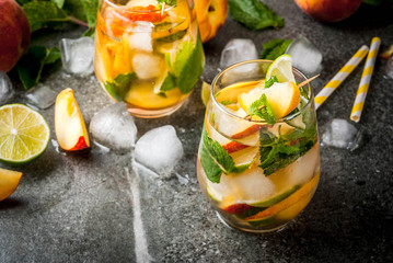 Summer refreshment drinks. Peach mojito with lime, peach and mint. With the ingredients on a dark...