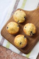 Homemade muffins with blueberries on a wooden board