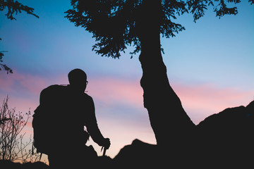 A man hikes in mountains at sunrise