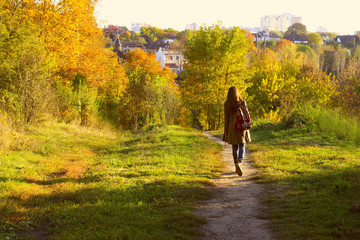 Young adult woman walking over autumn background.Shot of an attractive young woman in the park on an autumn day.