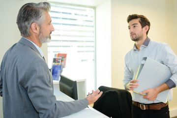 manager talking with young worker in office