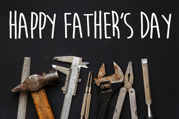 happy father's day text sign. fathers day greeting card. Working tools on black background top...