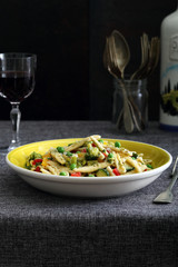 piatto di pasta vegetariana con verdure biologiche su sfondo scuro