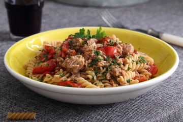 piatto di pasta italiana con pesce, tonno e pomodori