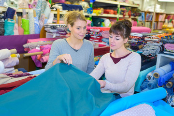 middle-aged dressmaker looking for fabrics at store