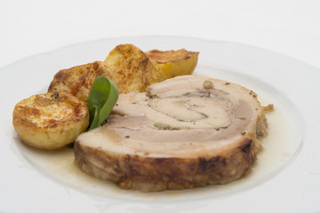 Slice roasted pork, served with potatoes and decorated with herbs, placed on white plate, light background, isolated