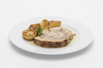 Slice roasted pork, served with potatoes and decorated with herbs, placed on white plate, light background, isolated