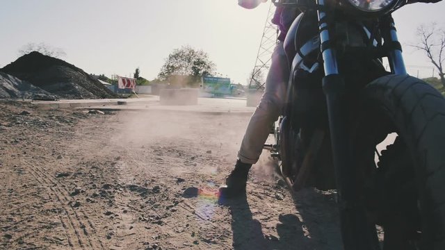 Motorcyclist doing tire burnout in the desert, slow motion