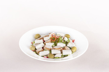 Grilled meat salad, served with parmesan and rucola, isolated on light background, white plate