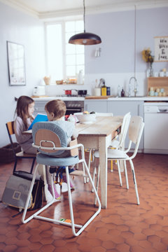 enfants &agrave; table dans la cuisine au go&ucirc;ter