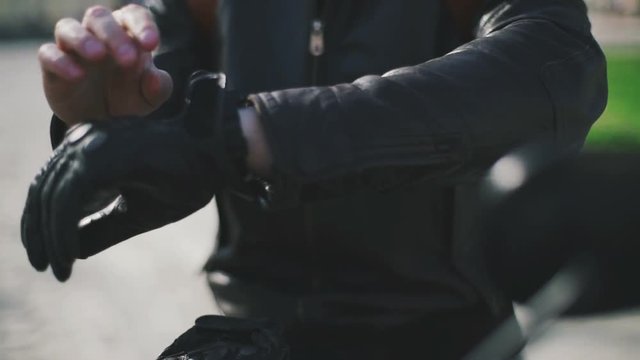 Close up shot of motorcyclist's put on his gloves