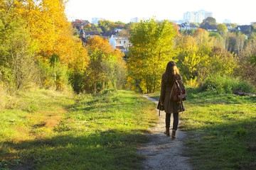 Attractive young woman walking in the forest. Young woman walking over autumn background.Shot of an attractive young woman in the park on an autumn day.
