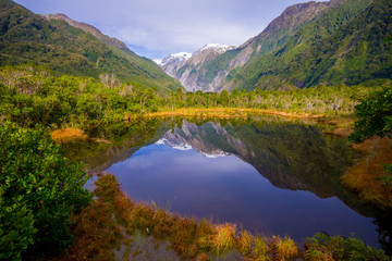 Naklejka na ściany i meble Small pond peters pond with reflection of mountain glacier Franz Josef Glacier in New Zealand