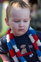 Young boy riding in red wagon having fun in the park for July Fourth