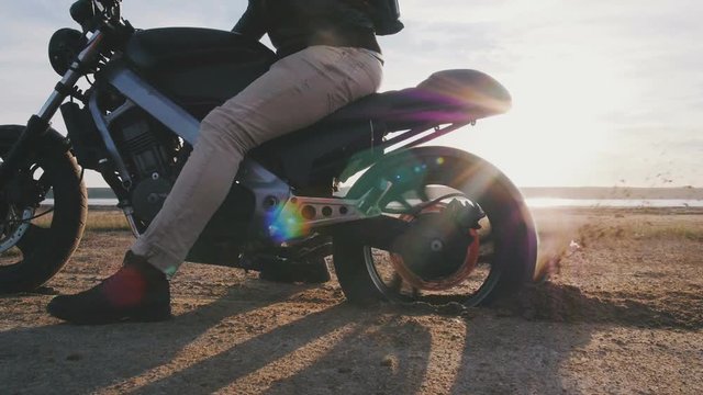Motorcyclist doing tire burnout in the desert, slow motion