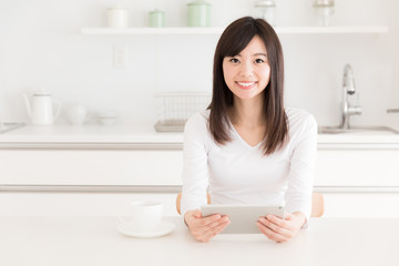 young asian woman relaxing in kitchen