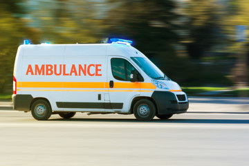 Ambulance on emergency call in motion blur with blue flashing light