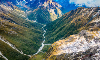 Beautiful landscape of the New Zealand - hills covered by green grass with mighty mountains covered by snow behind, South Island in New Zealand