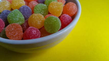 Sweet jujubes in white pot on yellow background