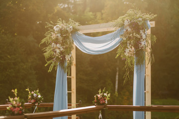 Beautiful wedding decoration for marriage registration, decoration set on the bridge in a beautiful place. Outdoor. Against the background of the lake. Sunny summer day.
