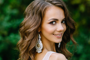 Beautiful bride. Expensive beautiful accessories. Make-up of the bride. Portrait of a young girl on wedding day. Photoshoot in a beautiful place and picturesque background