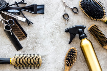 Combs and hairdress tools on stone table background top view copyspace